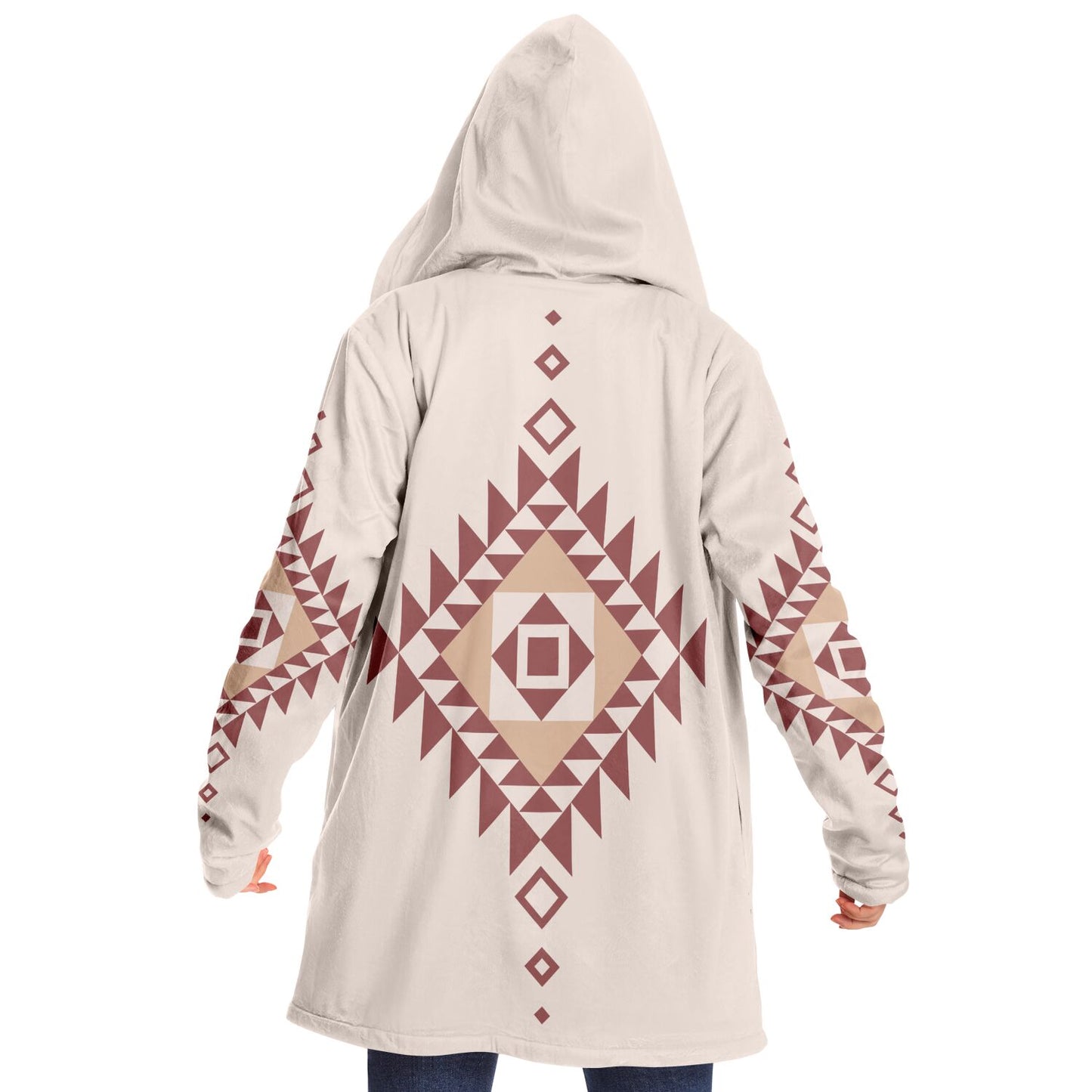 Woman wearing a cozy, hooded, beige microfleece cloak with a pink and tan Southwestern diamond shaped design on the back and elbows.