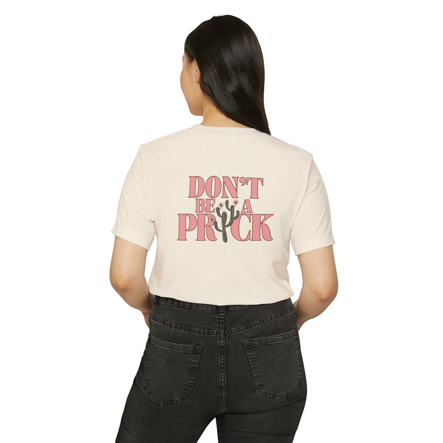 Woman wearing a natural beige recycled, organic, short sleeved t-shirt that says Don't Be A Prick on the back.