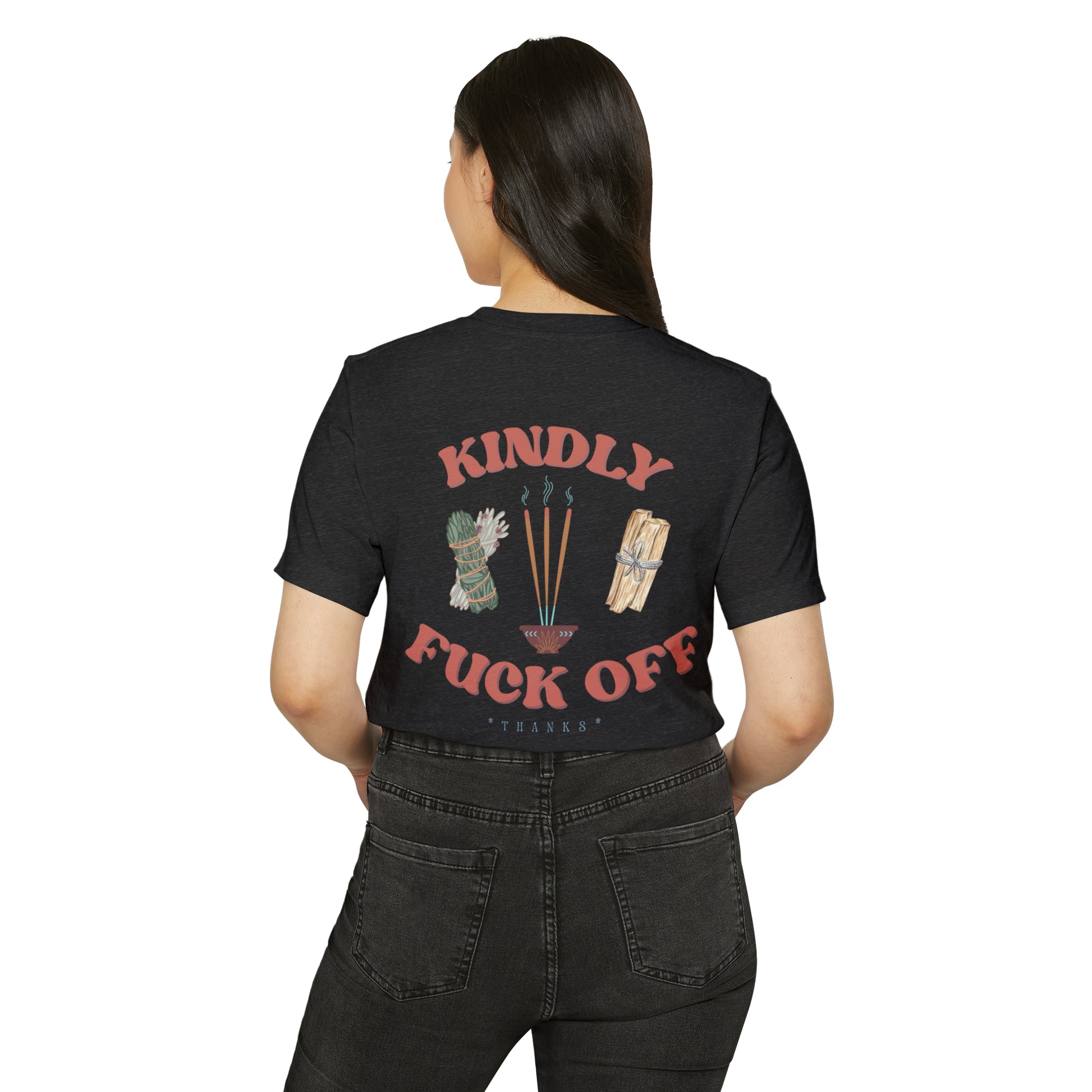 Woman wearing a dark grey recycled, organic, short sleeved t-shirt that says Kindly Fuck Off with graphics of sage, incense, and palo santo on the back.