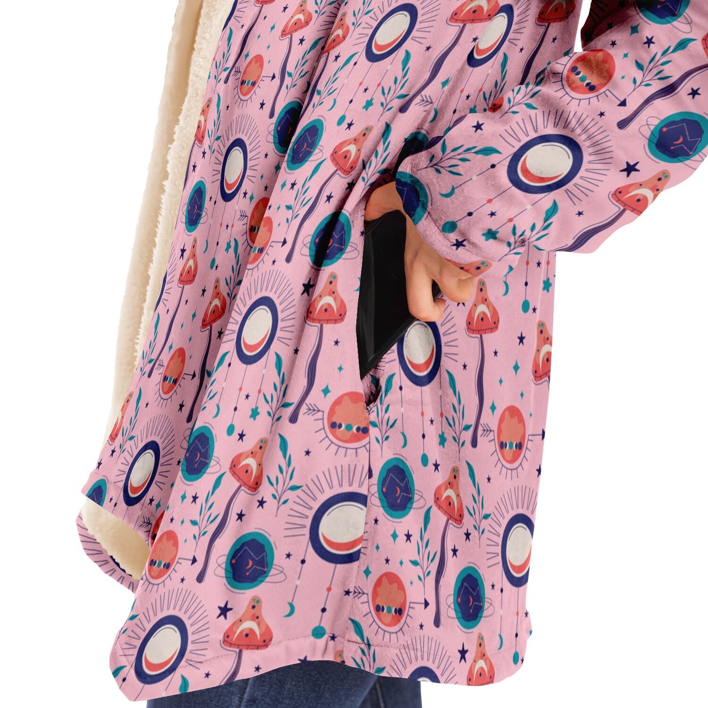 Woman wearing a cozy, hooded, pink microfleece cloak with a colorful, trippy mushroom design.