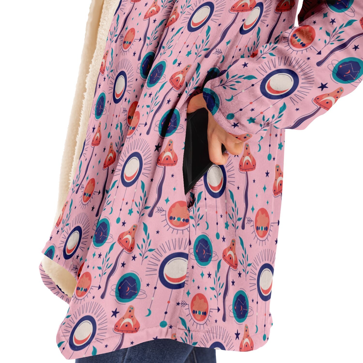 Woman wearing a cozy, hooded, pink microfleece cloak with a colorful, trippy mushroom design.
