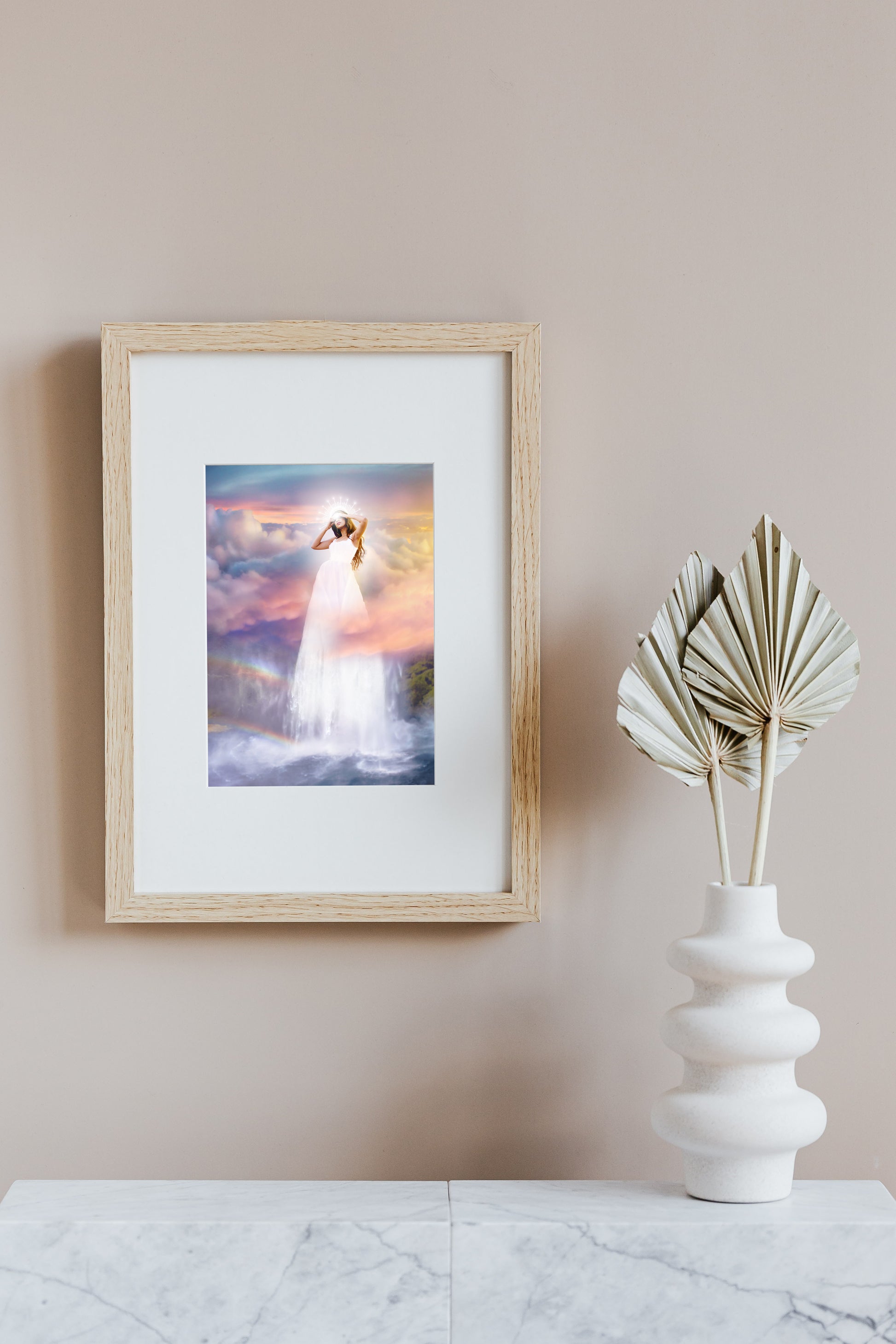 Woman in a white dress standing on a waterfall with a colorful sky and rainbow in the background.