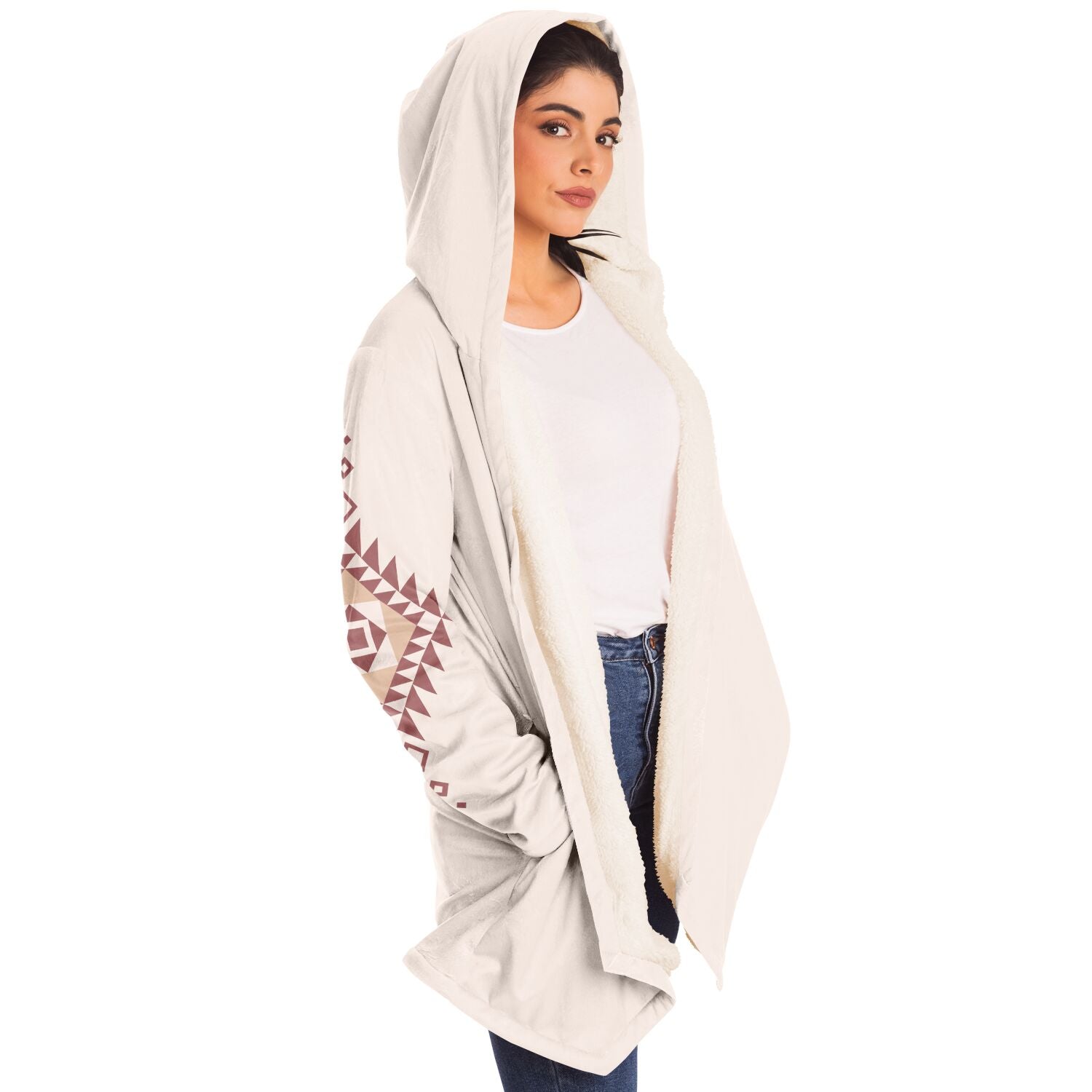 Woman wearing a cozy, hooded, beige microfleece cloak with a pink and tan Southwestern diamond shaped design on the back and elbows.