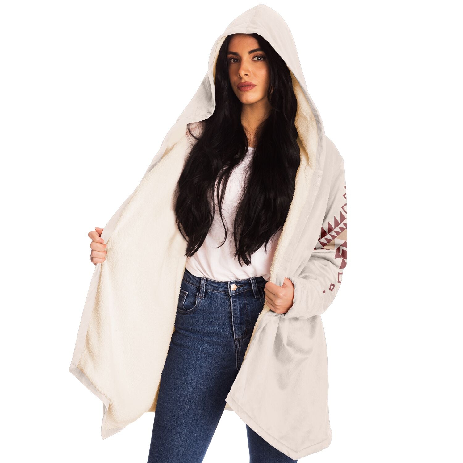 Woman wearing a cozy, hooded, beige microfleece cloak with a pink and tan Southwestern diamond shaped design on the back and elbows.