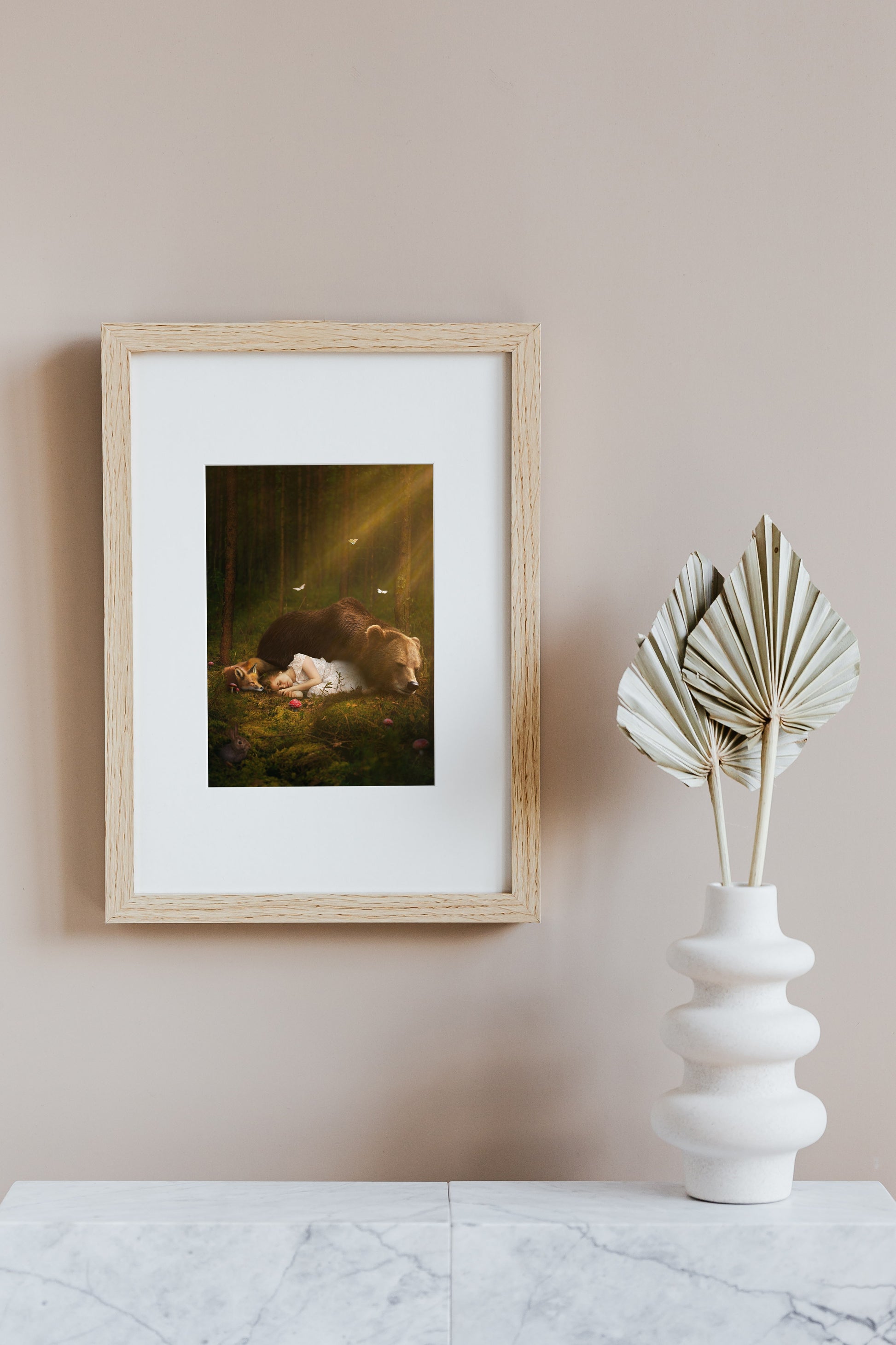 A magical scene of a young girl sleeping on the forest floor with a bear and a fox.