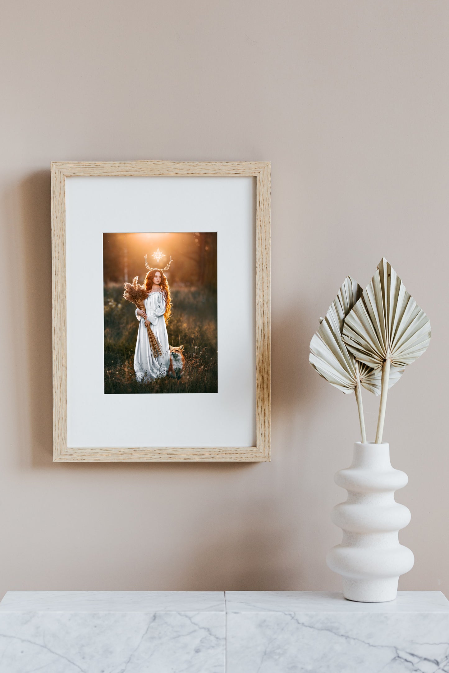 Woman in a white dress with a fox in a field at sunset.
