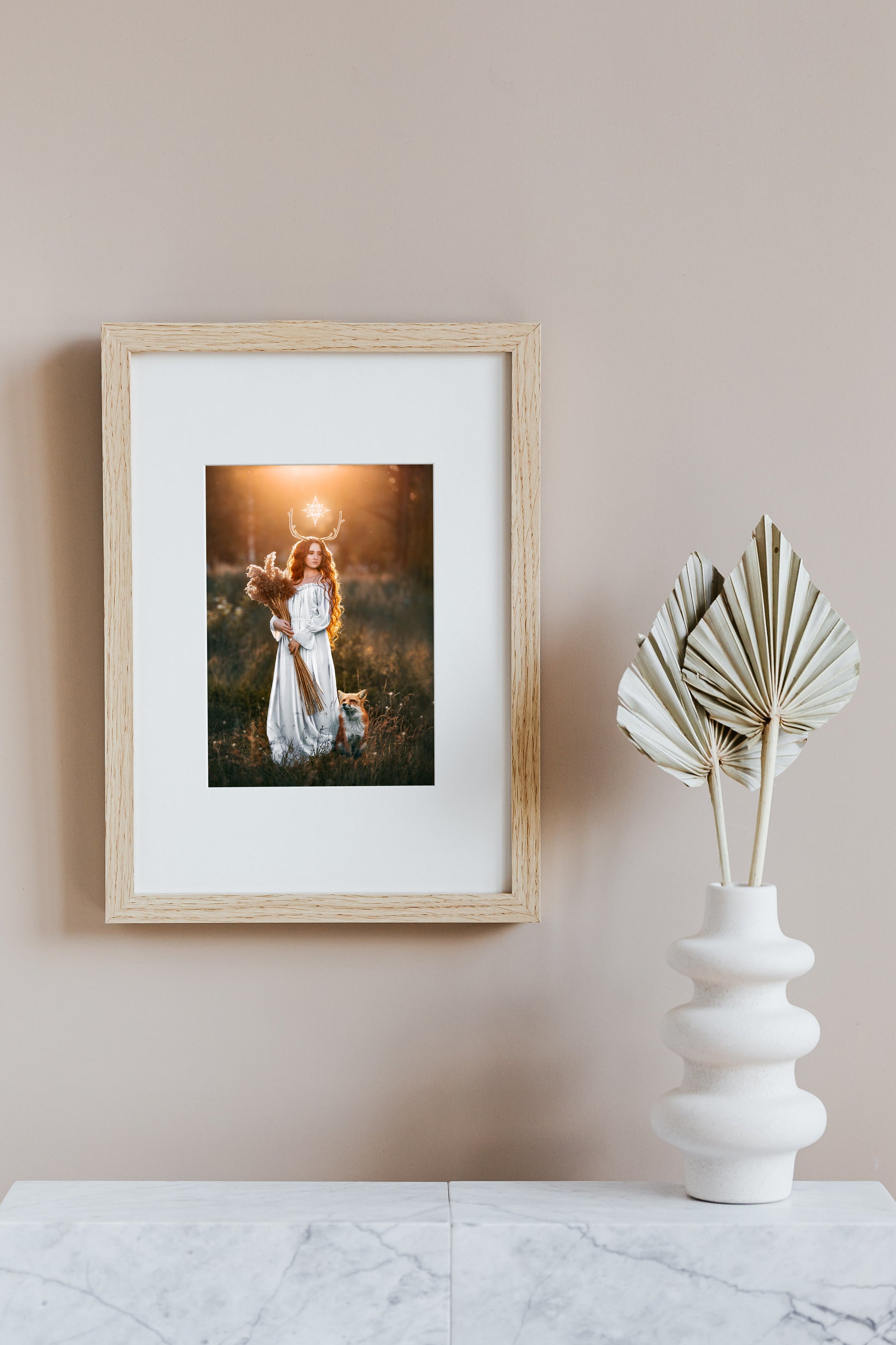 Woman in a white dress with a fox in a field at sunset.